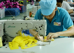 Worker operating sewing machine for bag production